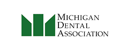 logo for the michigan dental association green on a white background