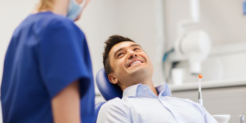 young man smiling while he visits the dentist