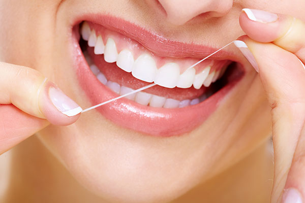 close-up of woman flossing her teeth